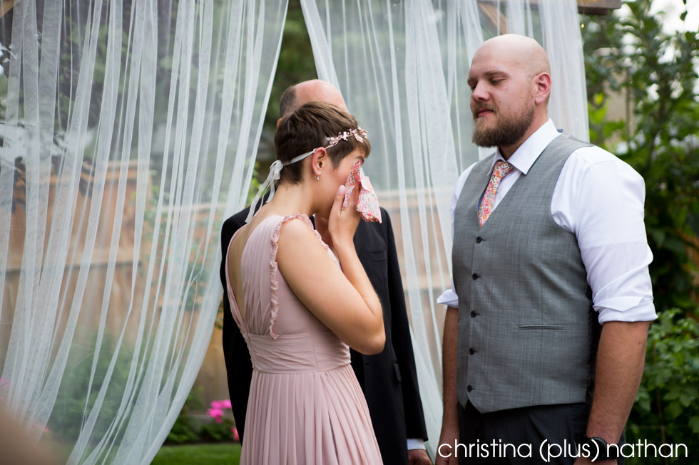 Bride cries at Calgary backyard wedding ceremony photographed by Calgary wedding photographers christina (plus) nathan