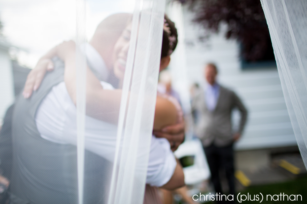 Artistic photograph of bride and groom hugging after wedding ceremony